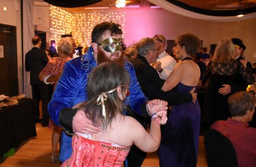 A man and woman dressed up and dancing to a live band at the Majestic Gala