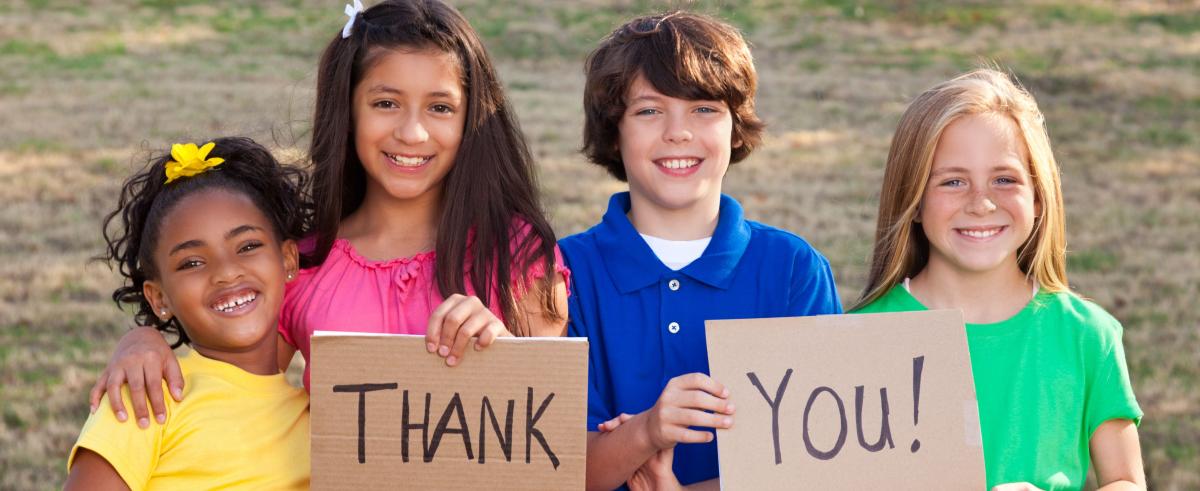 Four kids holding thank you sign